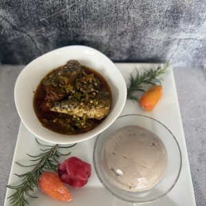 Plated NuSwan Superfood Fufu alongside a rich fish and okra stew, with colourful peppers and herbs for garnish